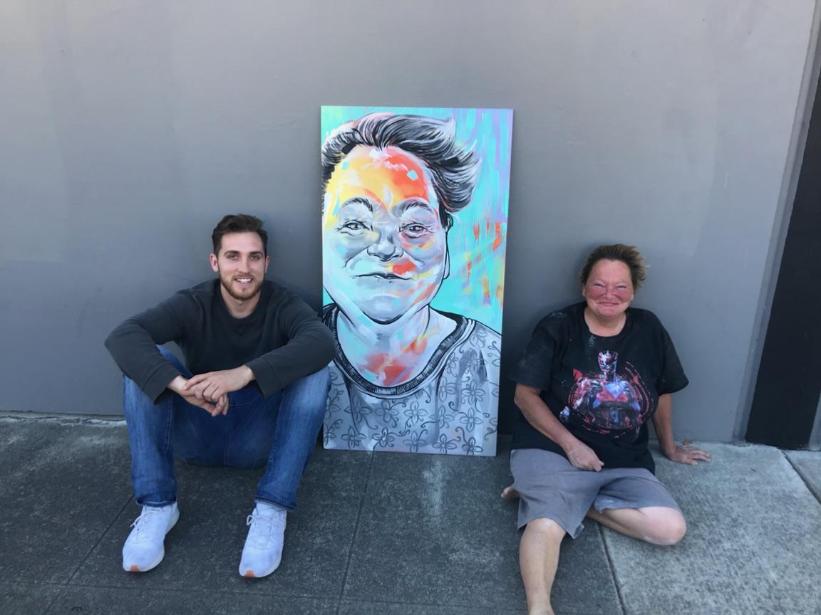 Two people sitting with painting
